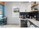 Stylish coffee bar area with white cabinets, black tile backsplash, and beverage cooler at 4131 E Roma Ave, Phoenix, AZ 85018