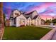 Striking two-story house with a manicured lawn, modern black and white exterior paint, and spacious three car garage at 4131 E Roma Ave, Phoenix, AZ 85018