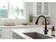 Modern kitchen features a stainless steel sink, matte black faucet, and a bright window overlooking the yard at 4131 E Roma Ave, Phoenix, AZ 85018