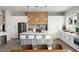 Bright, open kitchen with modern white cabinets, an island with seating, stainless steel appliances, and stylish light fixtures at 4131 E Roma Ave, Phoenix, AZ 85018