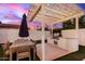Outdoor kitchen featuring a grill, granite countertop, an umbrella covered table with lights overhead at 4131 E Roma Ave, Phoenix, AZ 85018