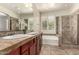 Bright bathroom featuring a double sink vanity, soaking tub, and a glass-enclosed shower at 418 W Balsam Dr, Chandler, AZ 85248