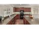 Bright kitchen with granite countertops, modern appliances, and dark wood cabinetry at 418 W Balsam Dr, Chandler, AZ 85248