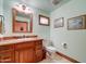 A cozy bathroom with a wood vanity, granite countertop, and framed mirror at 424 E Lehi Rd # 2, Mesa, AZ 85203
