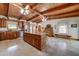 Kitchen with stainless appliances, island with seating, wood cabinets, and beamed vaulted ceilings at 424 E Lehi Rd # 2, Mesa, AZ 85203