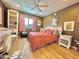 Bedroom with desk, ceiling fan, and window, with hardwood floors and brown colored walls at 4554 E Paradise Village N Pkwy # 133, Phoenix, AZ 85032