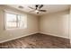 Bright bedroom with wood-look flooring, ceiling fan, and a window view at 4731 N 86Th Dr, Phoenix, AZ 85037