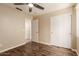 Bedroom with wood-look floors, a ceiling fan, closet, and attached bath at 4731 N 86Th Dr, Phoenix, AZ 85037