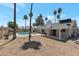 Expansive backyard featuring a refreshing pool, mature palm trees, and a covered patio at 4812 W Butler Dr, Chandler, AZ 85226