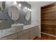 Bathroom featuring dual sinks, marble countertops, wood accent wall, and modern lighting at 4812 W Butler Dr, Chandler, AZ 85226