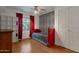 Bedroom featuring bright red daybed, a patterned accent wall, and wood floors at 4812 W Butler Dr, Chandler, AZ 85226