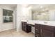 Bathroom with double sink vanity with dark wood cabinets and tan tile flooring at 503 N Ranger Trl, Gilbert, AZ 85234