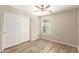 Bedroom features ceiling fan, wood-look floors, closet with sliding doors, and a window at 503 N Ranger Trl, Gilbert, AZ 85234