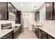 Modern kitchen with stainless steel appliances, dark cabinets, and light countertops at 503 N Ranger Trl, Gilbert, AZ 85234