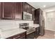 Kitchen with stainless steel appliances, dark wood cabinets and light countertop at 503 N Ranger Trl, Gilbert, AZ 85234