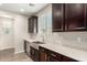 Kitchen featuring a stainless steel farmhouse sink and modern dark wood cabinets at 503 N Ranger Trl, Gilbert, AZ 85234