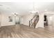 Open-concept living room with hardwood floors, modern lighting, and staircase access to the upper level at 503 N Ranger Trl, Gilbert, AZ 85234