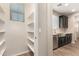 Pantry with white shelves next to kitchen with stainless steel sink at 503 N Ranger Trl, Gilbert, AZ 85234
