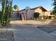 View of the house exterior with drought resistant landscaping, driveway, and basketball hoop at 5323 W North Ln, Glendale, AZ 85302