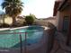 Sparkling private pool surrounded by lush greenery and a safety fence at 5323 W North Ln, Glendale, AZ 85302