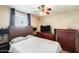 A comfortable bedroom with a ceiling fan, window with blinds, and matching dressers at 5734 S 21St Pl, Phoenix, AZ 85040