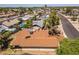 This aerial view captures a neighborhood featuring single-Gathering homes, lush landscaping, and a community swimming pool at 6015 W Acoma Dr, Glendale, AZ 85306