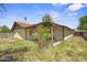 Back exterior of the house with stucco, desert landscaping, and a covered patio at 6015 W Acoma Dr, Glendale, AZ 85306