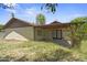 Back exterior of the house with stucco, desert landscaping, and a covered patio at 6015 W Acoma Dr, Glendale, AZ 85306