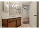 View of the bathroom featuring a sink with cabinet, vanity mirror, and doorway to bedroom at 6015 W Acoma Dr, Glendale, AZ 85306