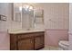 View of the bathroom featuring sink with vanity, toilet, and floral patterned wallpaper at 6015 W Acoma Dr, Glendale, AZ 85306