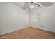 Empty bedroom featuring carpet, a window with blinds, and a ceiling fan at 6015 W Acoma Dr, Glendale, AZ 85306