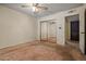 View of primary bedroom with carpet, ceiling fan, and closet with sliding mirrored doors at 6015 W Acoma Dr, Glendale, AZ 85306