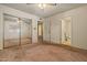 Bedroom with carpeted floors, mirrored closet, and a bathroom in the background at 6015 W Acoma Dr, Glendale, AZ 85306
