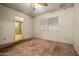 Bedroom view with carpeted floors, a ceiling fan, and a bathroom in the background at 6015 W Acoma Dr, Glendale, AZ 85306