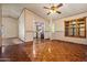 Dining room featuring wood floors, a ceiling fan, and open access to the kitchen at 6015 W Acoma Dr, Glendale, AZ 85306