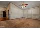 Living room showcasing neutral carpet, ceiling fan, and adjacent hallway at 6015 W Acoma Dr, Glendale, AZ 85306