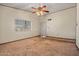 The carpeted living room has natural light from the window and a ceiling fan at 6015 W Acoma Dr, Glendale, AZ 85306