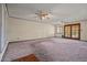 Spacious living room featuring carpet, ceiling fans, and glass-paneled doors at 6015 W Acoma Dr, Glendale, AZ 85306
