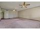 Spacious living room featuring two ceiling fans and neutral colored walls at 6015 W Acoma Dr, Glendale, AZ 85306