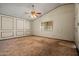 Spacious living room featuring neutral carpeting, a ceiling fan, and ample natural light at 6015 W Acoma Dr, Glendale, AZ 85306