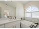 Inviting bathroom featuring a large soaking tub, vanity with plenty of counter space, and natural light at 6029 E Palm St, Mesa, AZ 85215