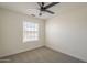 Bright bedroom features a ceiling fan, neutral carpet and a window with light-filtering blinds at 6029 E Palm St, Mesa, AZ 85215