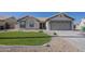 Inviting single-story home featuring a landscaped yard and a covered entrance and a two car garage at 6029 E Palm St, Mesa, AZ 85215