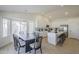Eat-in kitchen with white cabinets, island with bar stools, stainless appliances, and dining table at 6029 E Palm St, Mesa, AZ 85215