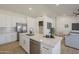 Modern kitchen with white cabinetry, stainless steel appliances, quartz countertops, and breakfast bar seating at 6029 E Palm St, Mesa, AZ 85215