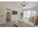 Primary bedroom with outdoor views, soft carpet, TV, and access to closet and en-suite bathroom at 6029 E Palm St, Mesa, AZ 85215