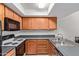 Bright kitchen space boasting plenty of oak cabinetry, a smooth gray countertop, and modern appliances at 609 E Mesquite Cir # D133, Tempe, AZ 85288