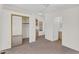 Bright bedroom featuring neutral carpeting, white walls, an ensuite, and a closet with mirrored doors at 6461 S Oakmont Dr, Chandler, AZ 85249