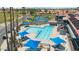 Community pool with blue umbrellas, lounge chairs, and clear water surrounded by lush landscaping and palm trees at 6461 S Oakmont Dr, Chandler, AZ 85249