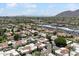 Stunning aerial view of a community with red tile roofs and lush landscaping, set against a backdrop of mountains at 7319 E Rose Ln, Scottsdale, AZ 85250